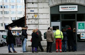 Inimesed Genfis valuutavahetuskontori ukse taga järjekorras.